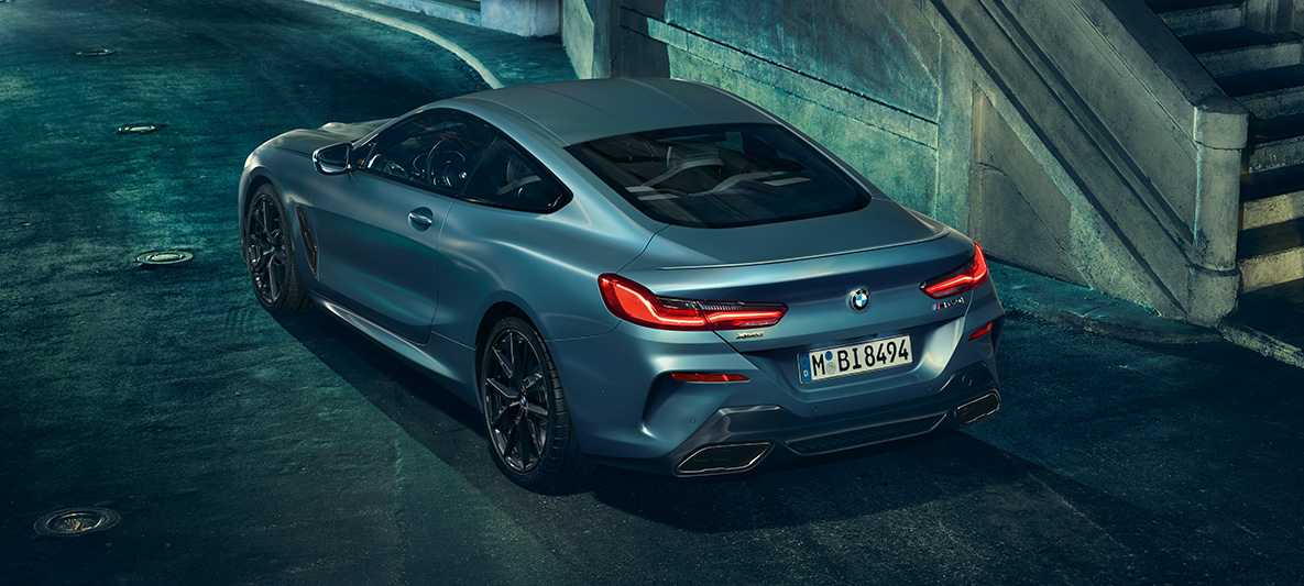 BMW M850i xDrive First Edition, tříčtvrteční pohled zezadu Tříčtvrteční staticky pohled zezadu na BMW M850i Coupé First Edition v městském prostředí.