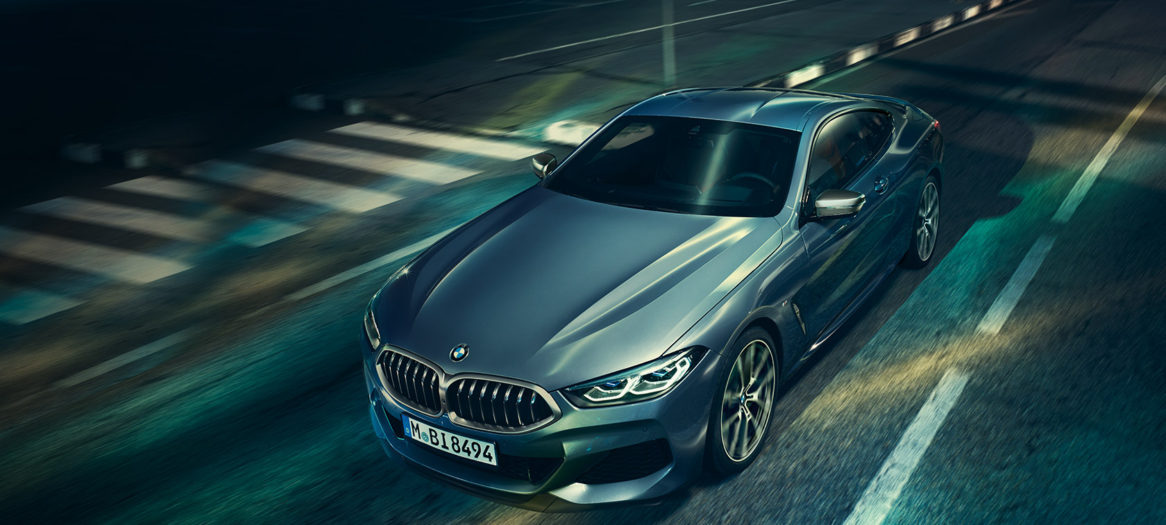 BMW řady 8 Coupé, tříčtvrteční pohled zepředu. BMW řady 8 Coupé, tříčtvrteční statický pohled zpředu s detailním záběrem na kapotu motoru.