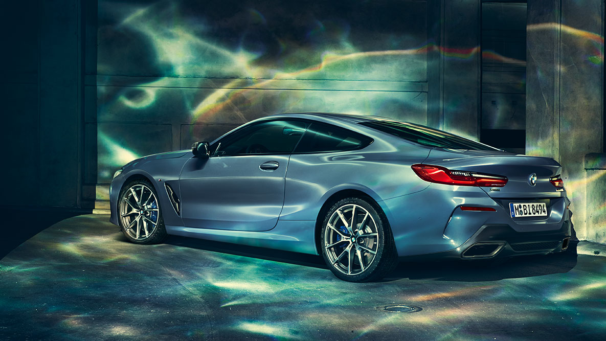 BMW řady 8 Coupé, tříčtvrteční pohled zezadu. BMW řady 8 Coupé při pohledu zezadu ze tří čtvrtin v městském prostředí.