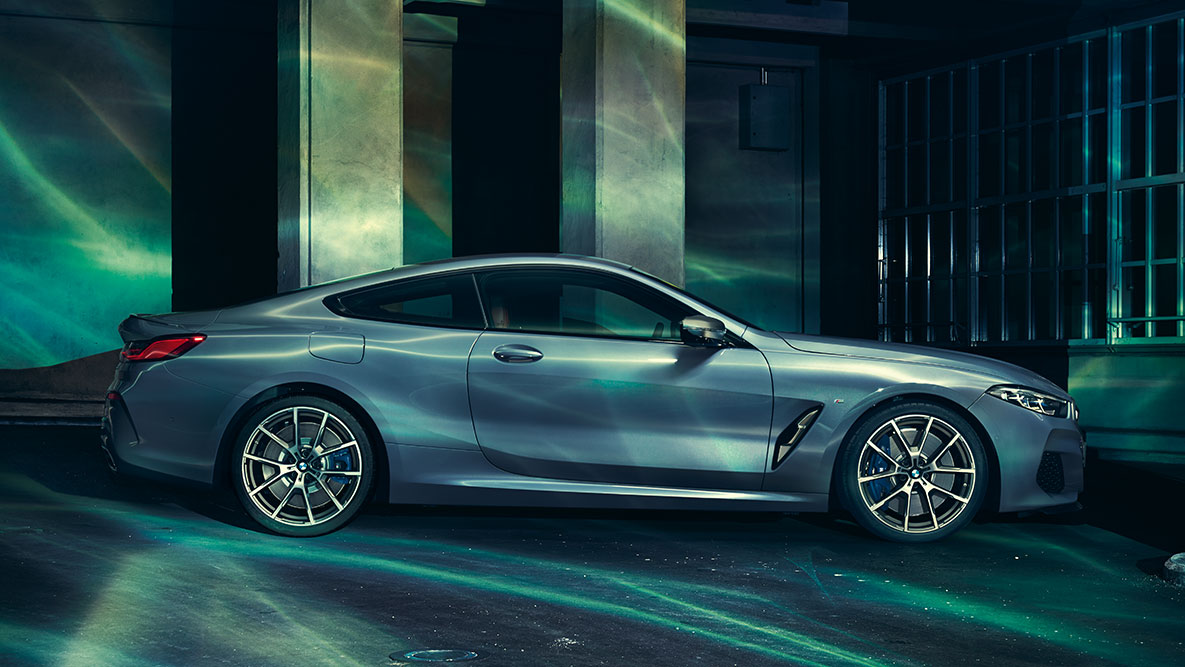 BMW řady 8 Coupé, boční pohled. Statický záběr na BMW řady 8 Coupé při pohledu z boku v městském prostředí.