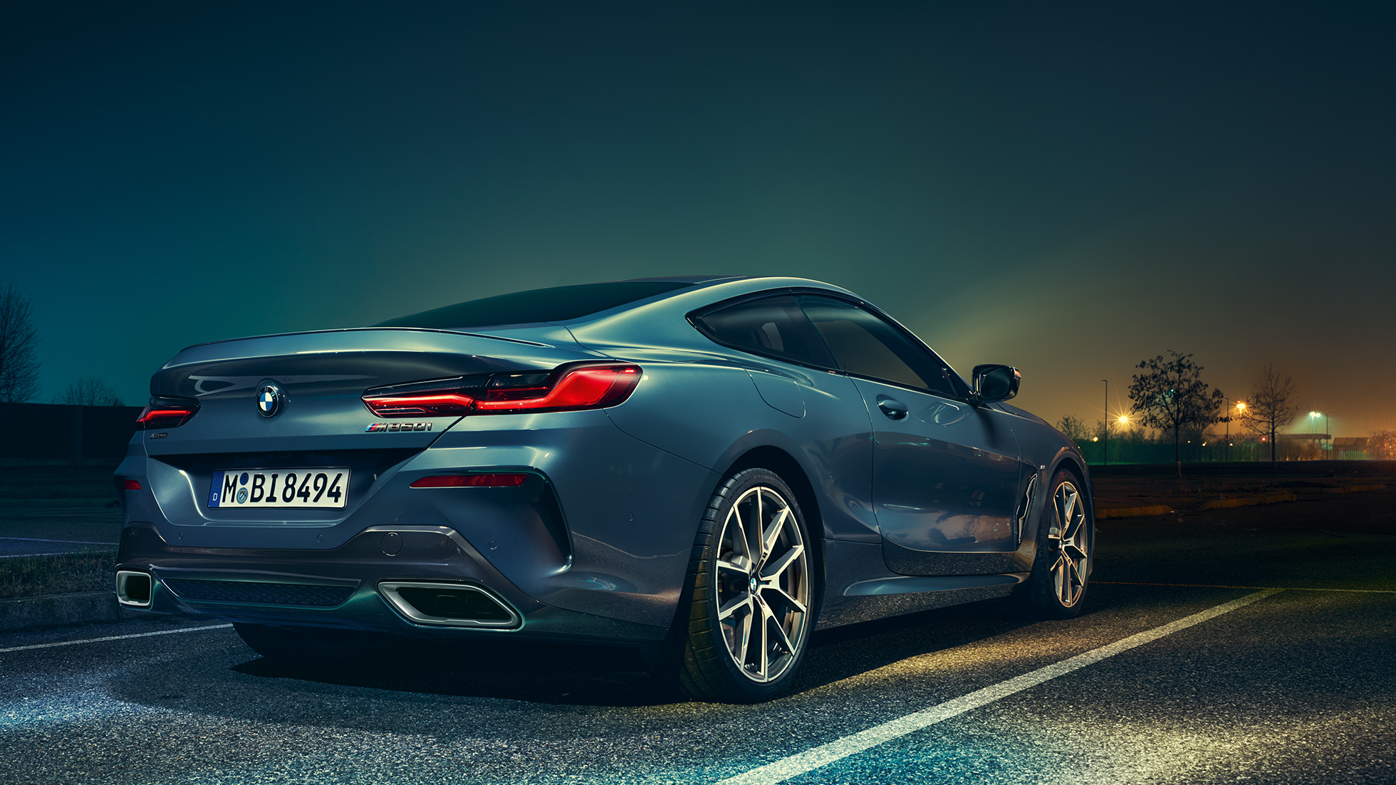 BMW řady 8 Coupé, tříčtvrteční pohled zezadu. BMW řady 8 Coupé, tříčtvrteční pohled zezadu, stojící před noční scenérií.