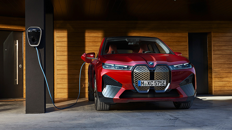BMW iX i20 elektrické SUV BMW iX xDrive50 jízdní výkony BMW iX i20 2021 elektrické SUV BMW iX xDrive50 Aventurin Red (červená) jedoucí po silnici jízdní výkony