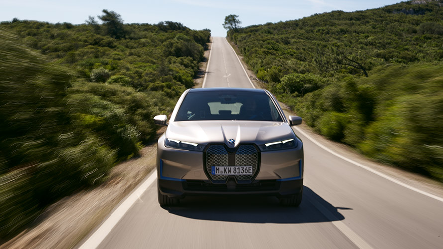 BMW iX pohled zepředu na silnici BMW iX Cashmere Silver i20 pohled zepředu na silnici