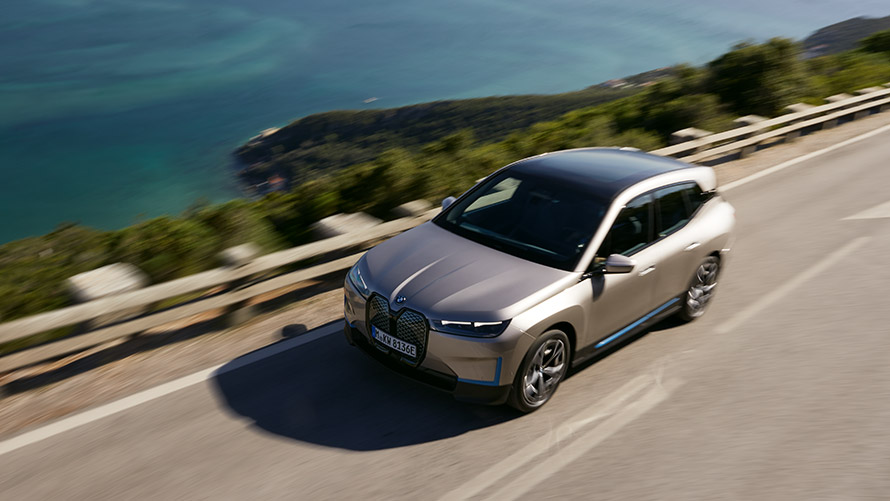 BMW iX na silnici při pohledu shora BMW iX Cashmere Silver i20 na silnici při pohledu shora