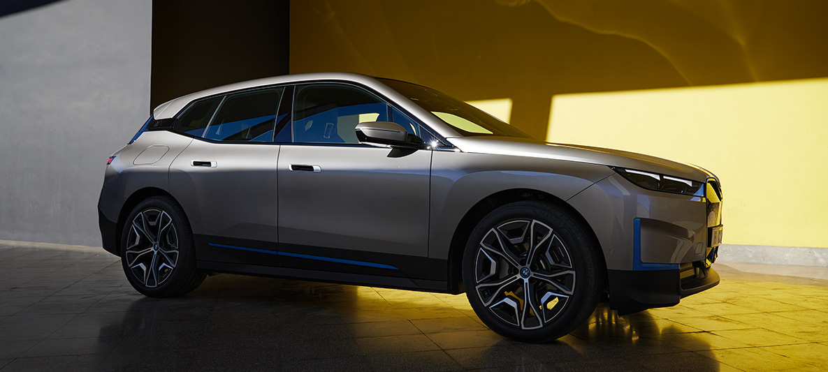 BMW iX tříčtvrteční pohled z boku stojící BMW iX Cashmere Silver i20 tříčtvrteční pohled z boku stojící
