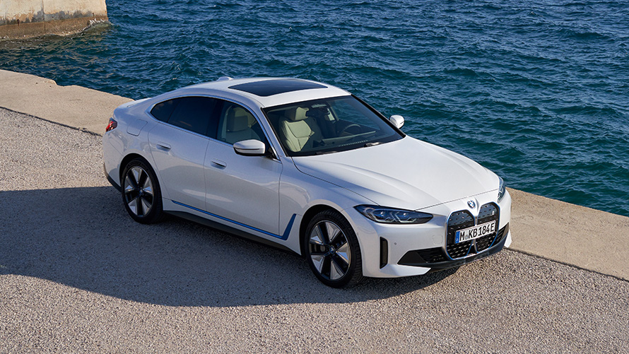 Tříčtvrteční pohled zepředu BMW i4 eDrive40 G26 2021 na nábřeží BMW i4 eDrive40 G26 2021 Mineral White (bílá) tříčtvrteční pohled zepředu na nábřeží