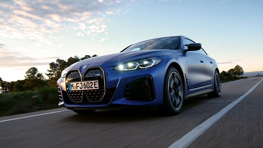 Tříčtvrteční pohled zepředu BMW i4 M50 G26 2021 záběr zespoda BMW i4 M50 G26 2021 metalický lak Individual Frozen Portimao Blue (modrá) tříčtvrteční jízdní záběr zespoda zepředu