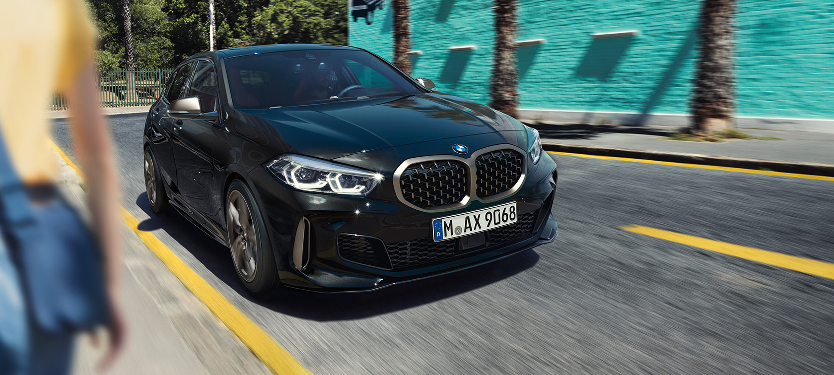 BMW M135i xDrive, tříčtvrteční pohled zepředu. BMW řady 1 v černé metalíze Black Sapphire, dynamický tříčtvrteční pohled zepředu.