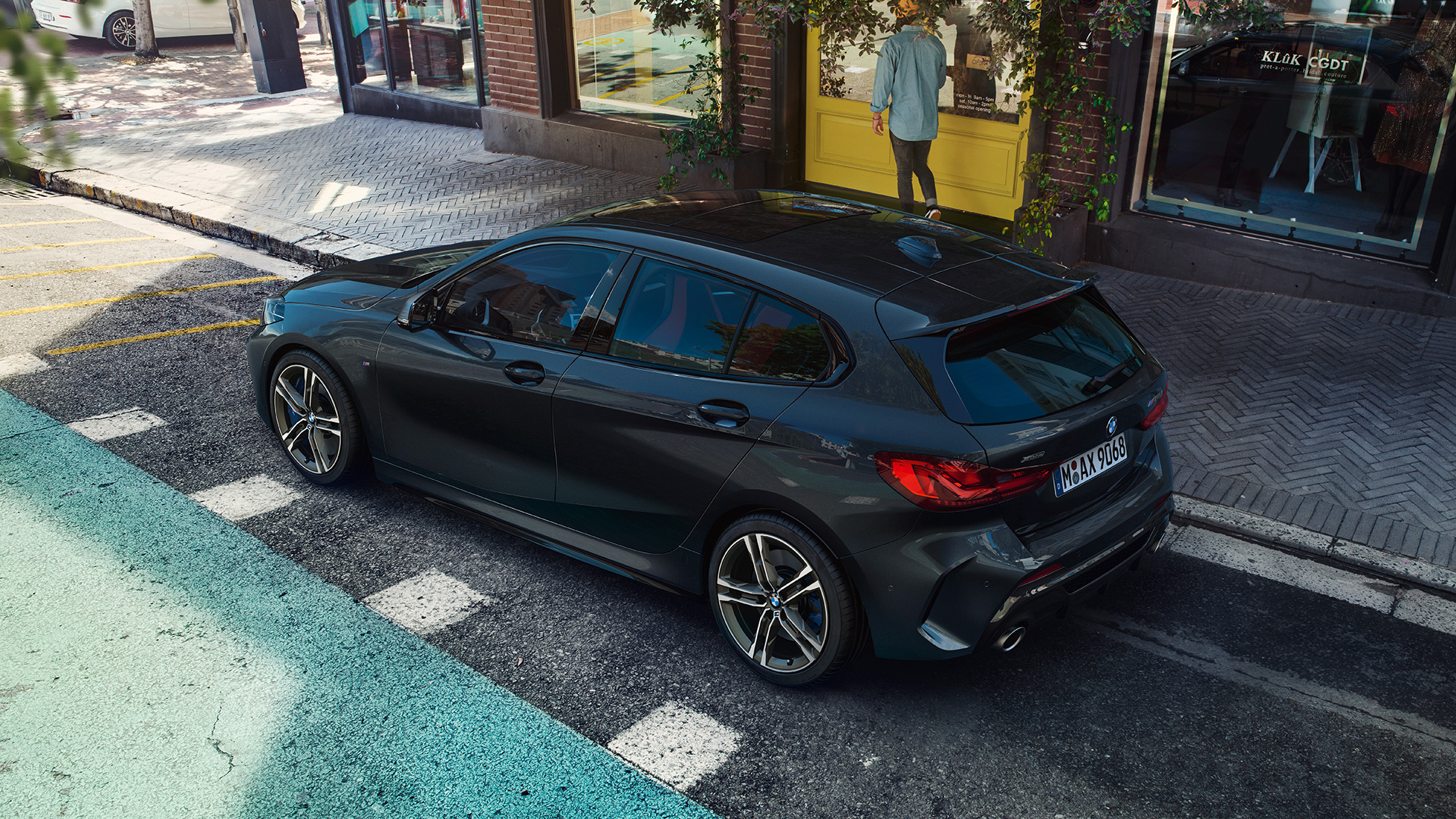 Parkující BMW M135i xDrive. BMW M135i xDrive v černé metalíze Black Sapphire, boční pohled z ptačí perspektivy na parkující vůz.