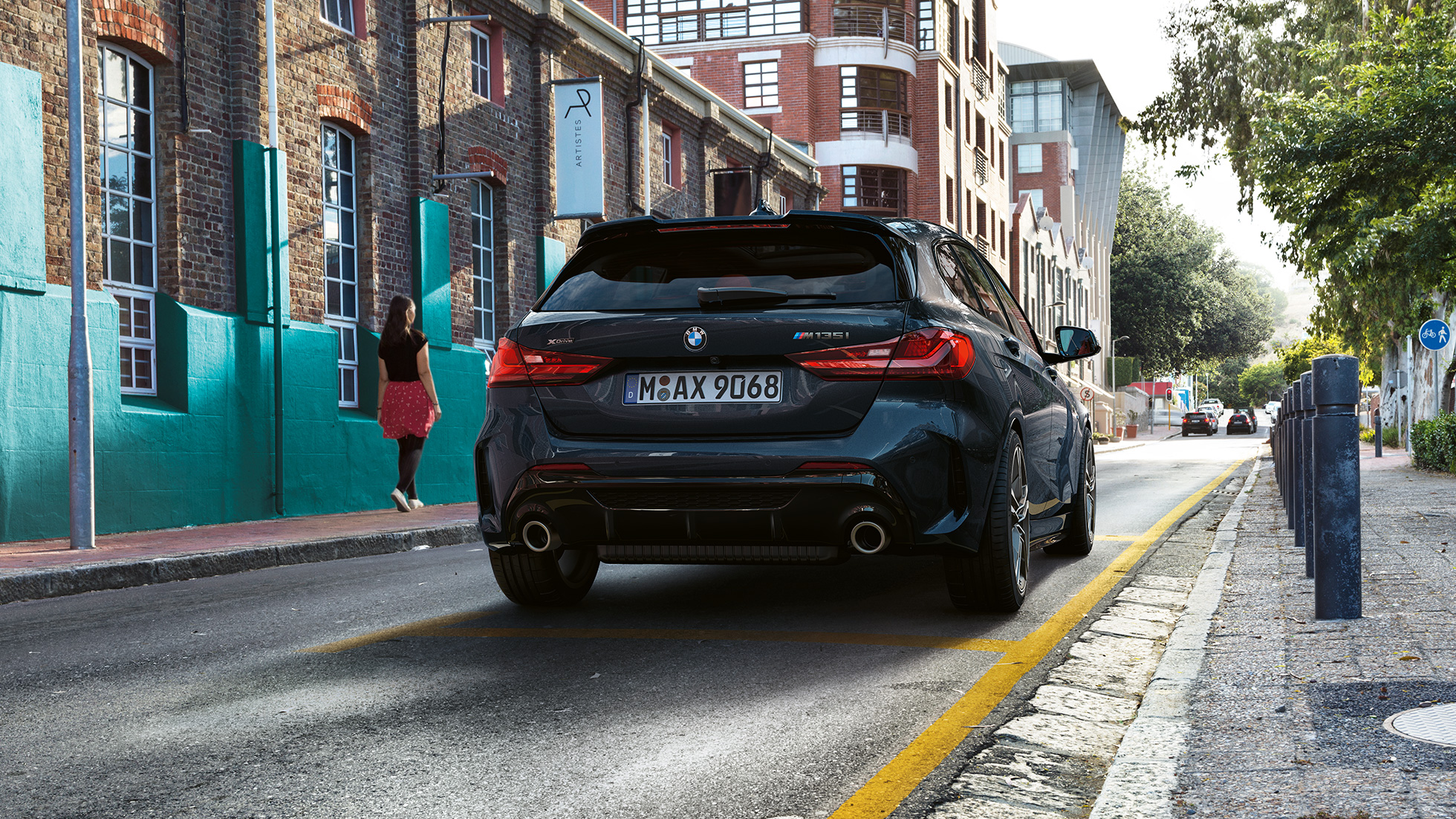 BMW M135I xDrive, pohled zezadu. BMW M135i xDrive v černé metalíze Black Sapphire, pohled zezadu na parkující vůz.