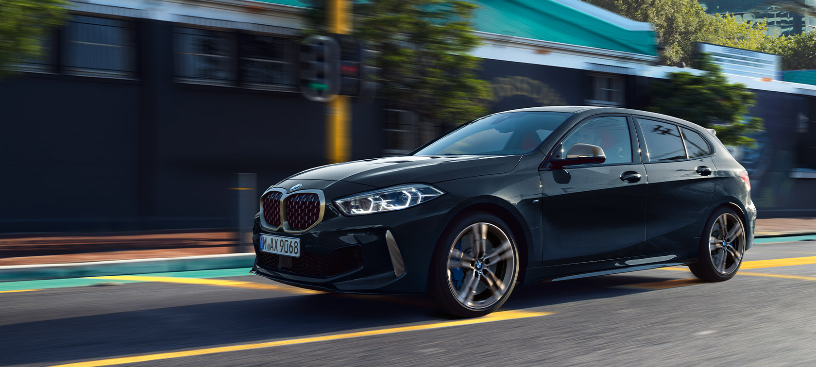 BMW řady 1 M135i xDrive (F40) v metalickém laku Sapphire Black (černá) Jedoucí záběr v městském prostředí