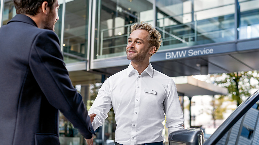 Zaměstnanec BMW Servisu se zdraví se zákazníkem Zaměstnanec BMW Servisu se zdraví se zákazníkem