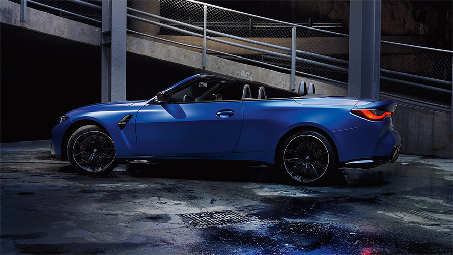 BMW M4 Competition Cabrio s pohonem M xDrive G83 2021 z bočního pohledu se staženou střechou BMW M4 Competition Cabrio s pohonem M xDrive G83 2021 v metalické Frozen Portimao Blue (modrá) z bočního pohledu se staženou střechou