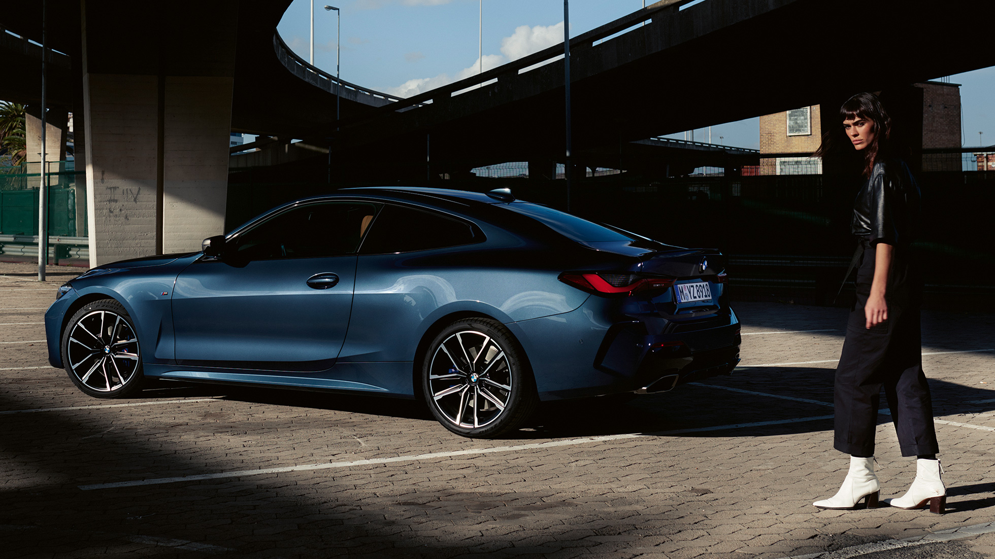 Tříčtvrteční pohled zezadu s modelem BMW M440i xDrive Coupé G22 2020 BMW M440i xDrive Coupé v metalické barvě Arctic Race Blue (modrá) G22 2020 ze tříčtvrtečního pohledu zezadu s modelem