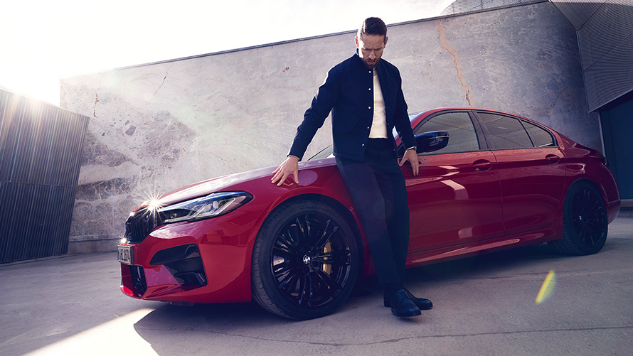 BMW M5 Competition F90 LCI Facelift 2020 v barvě BMW Invidividual Imola Red (červená) tříčtvrteční pohled zepředu s mužem