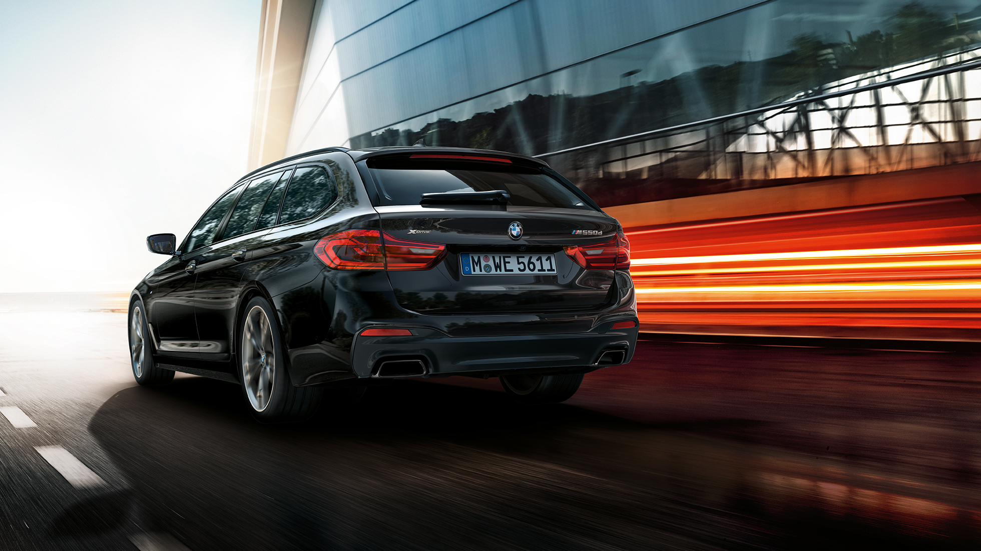 Tříčtvrteční pohled zezadu BMW M550d xDrive Touring BMW M550d xDrive Touring G31 v metalickém laku Azurite Black (černá) ze tříčtvrtečního pohledu zezadu
