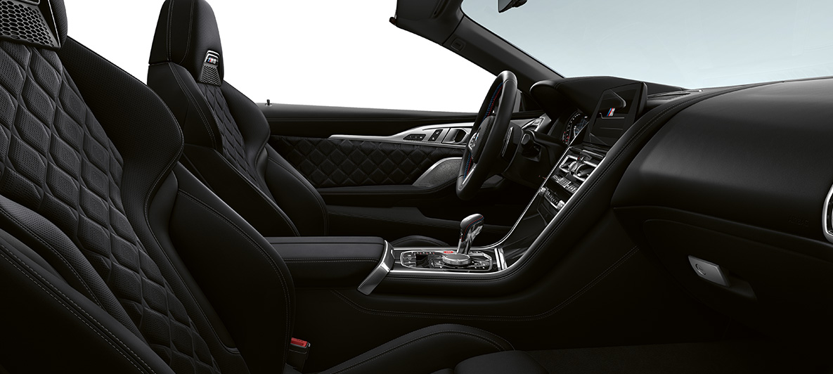 Celokožené čalounění Merino | Black a leskle černé obložení interiéru BMW Individual Piano Finish Black. BMW M8 Competition Cabrio, interiér v celokoženém čalounění jemnou kůží Merino | Black a obložení interiéru BMW Individual Piano Finish Black.