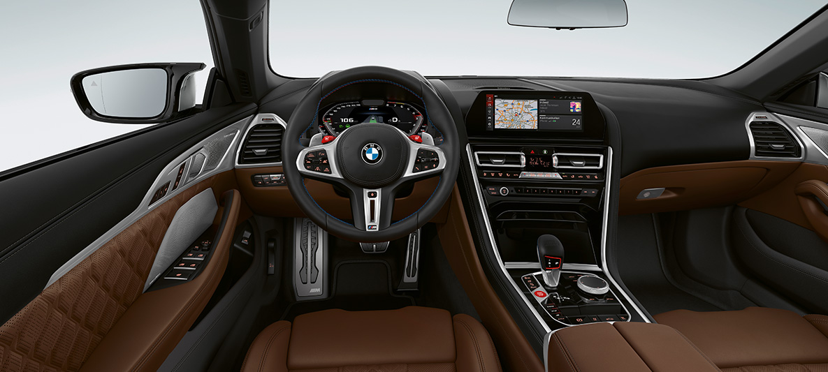 BMW M8 Cabrio, interiér. BMW M8 Cabrio, kokpit s M koženým volantem s tlačítky M1/M2 v červené barvě.