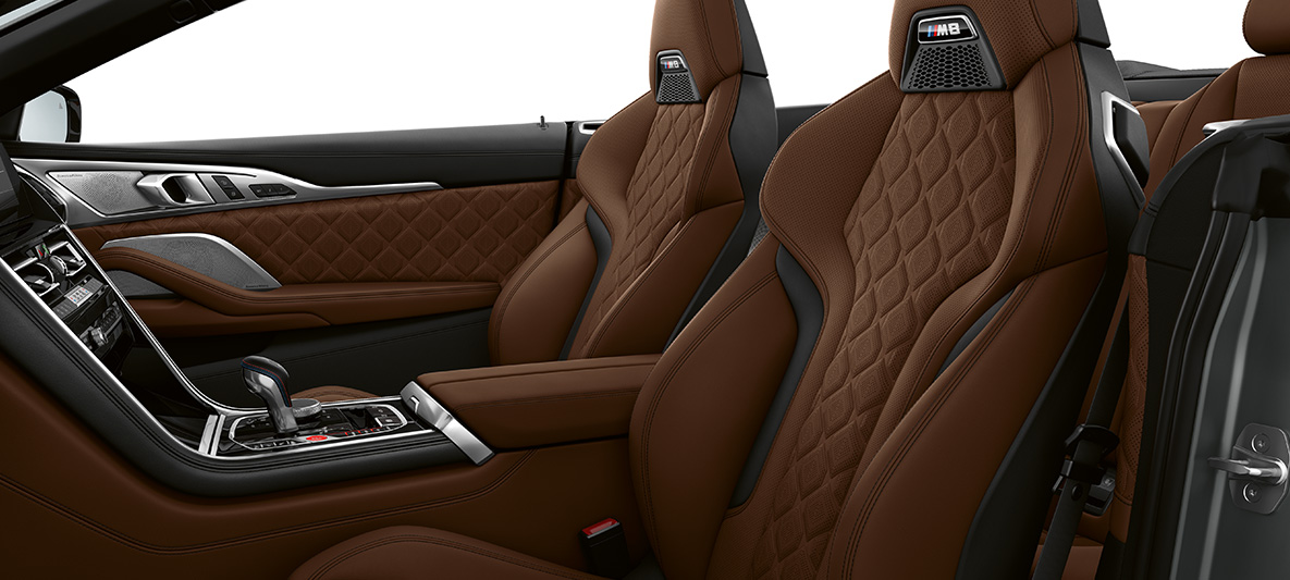 M sportovní sedadla s M znakem. BMW M8 Cabrio, interiér s M sportovními sedadly čalouněnými jemnozrnnou kůží Merino v provedení hnědá Taruma Brown.