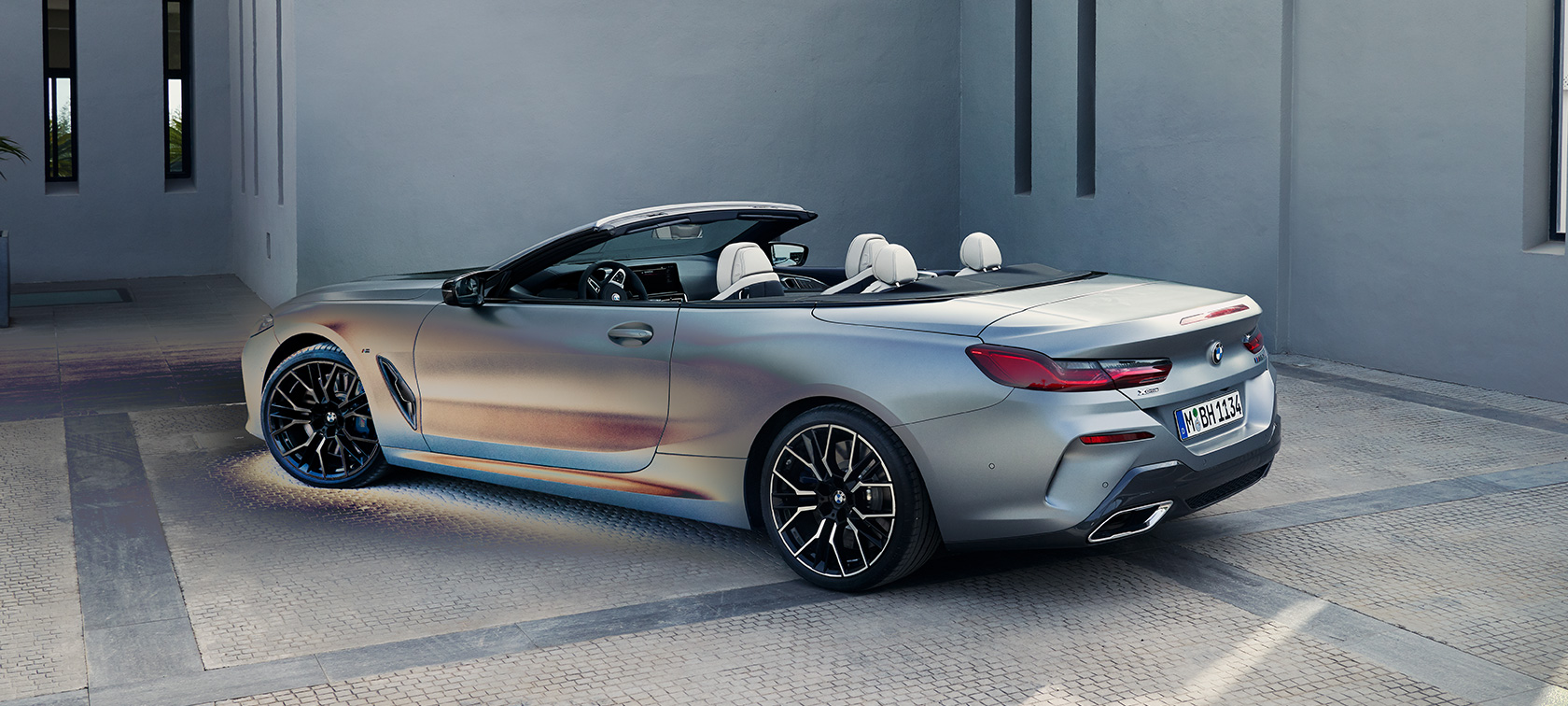 Tříčtvrteční pohled zezadu BMW M850i xDrive Cabrio G14 LCI Facelift 2022 BMW M850i xDrive Cabrio G14 LCI Facelift 2022 metalický lak BMW Individual Frozen Pure Grey (šedá) ze tříčtvrtečního pohledu zezadu