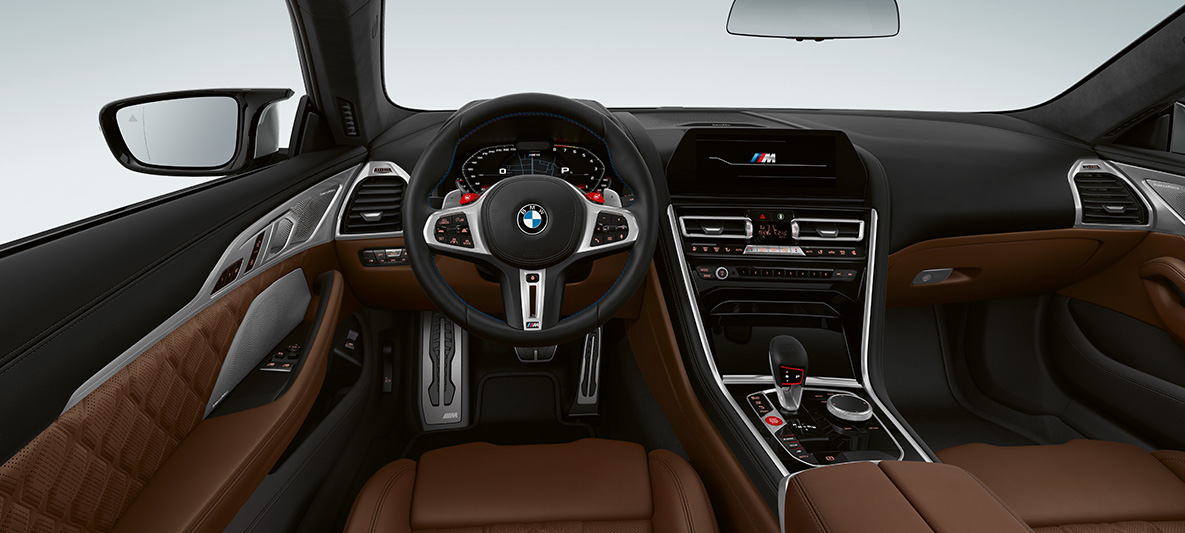 BMW M8 Coupé, interiér. BMW M8 Coupé, kokpit s M koženým volantem s tlačítky M1/M2 v červené barvě.