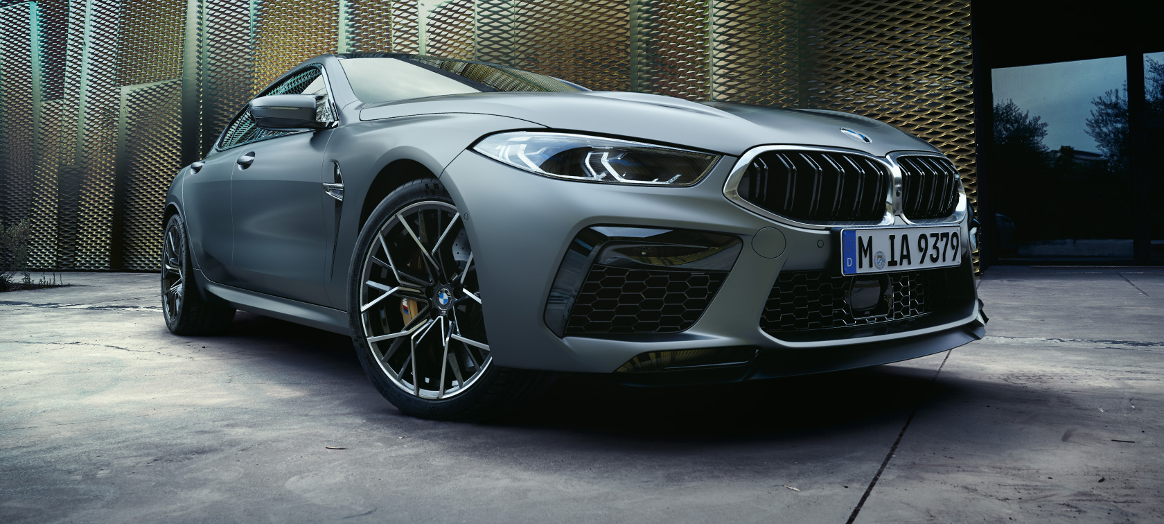 Tříčtvrteční pohled zepředu BMW M8 Gran Coupé F93 LCI Facelift 2022 BMW M8 Gran Coupé F93 LCI Facelift 2022 v metalické barvě BMW Invidividual Frozen Brilliant White (bílá) ze tříčtvrtečního pohledu zepředu od země