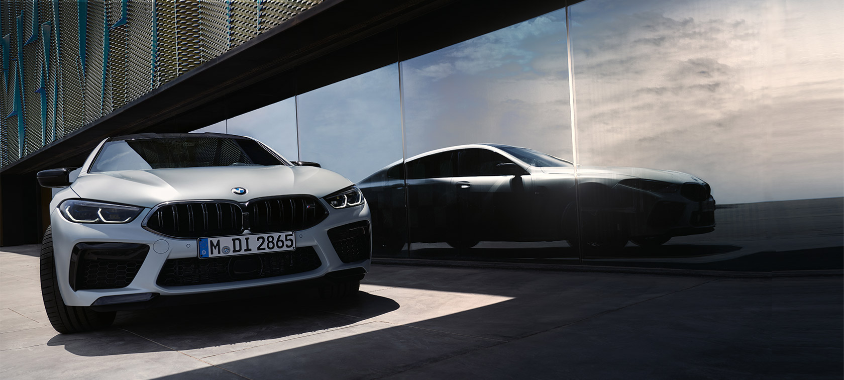 Pohled zepředu BMW M8 Competition Gran Coupé F93 LCI Facelift 2022 BMW M8 Competition Gran Coupé F93 LCI Facelift 2022 v metalické barvě BMW Individual BMW Invidividual Frozen Brilliant White (bílá) pohled zepředu s odrazem siluety na okně vpředu