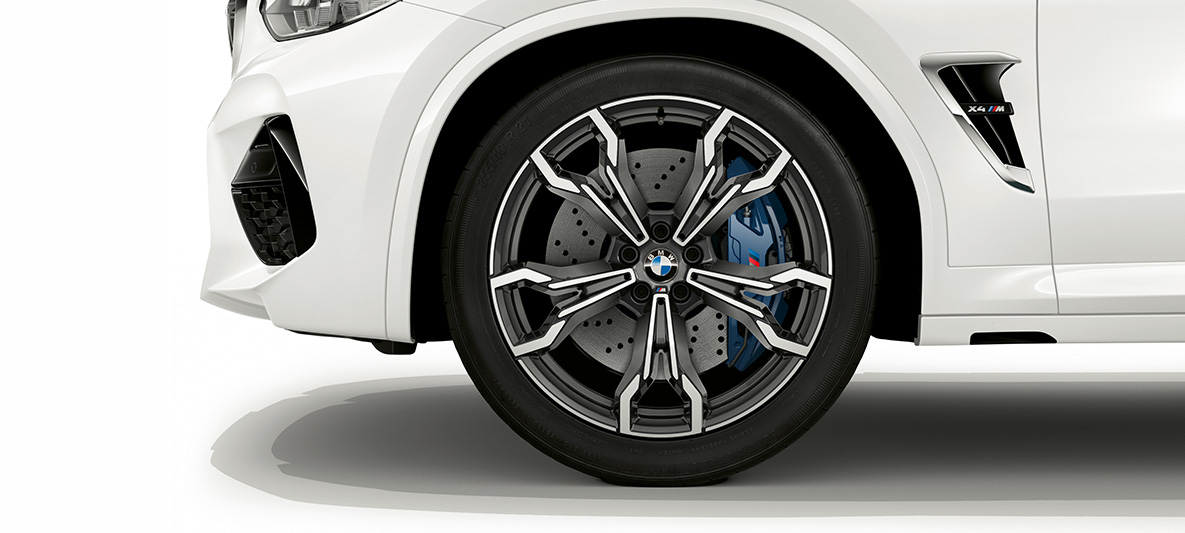 BMW X4 M v bílé barvě Alpine White, 21palcová M kola z lehké slitiny v šedém provedení Orbit Grey. BMW X4 M v bílé barvě Alpine White, exteriér, 21palcová M kola z lehké slitiny v šedém provedení Orbit Grey.