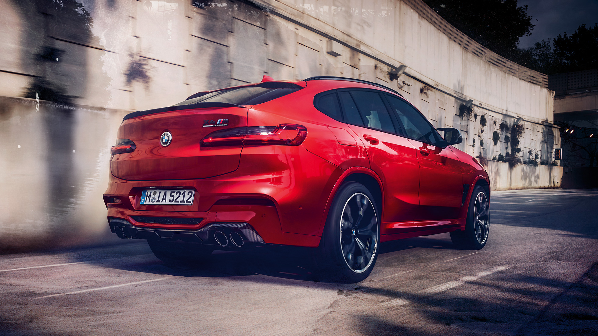 BMW X4 M Competition, boční pohled na zadní část. BMW X4 M Competition v červené metalické barvě Toronto Red, exteriér, boční pohled na zadní část.