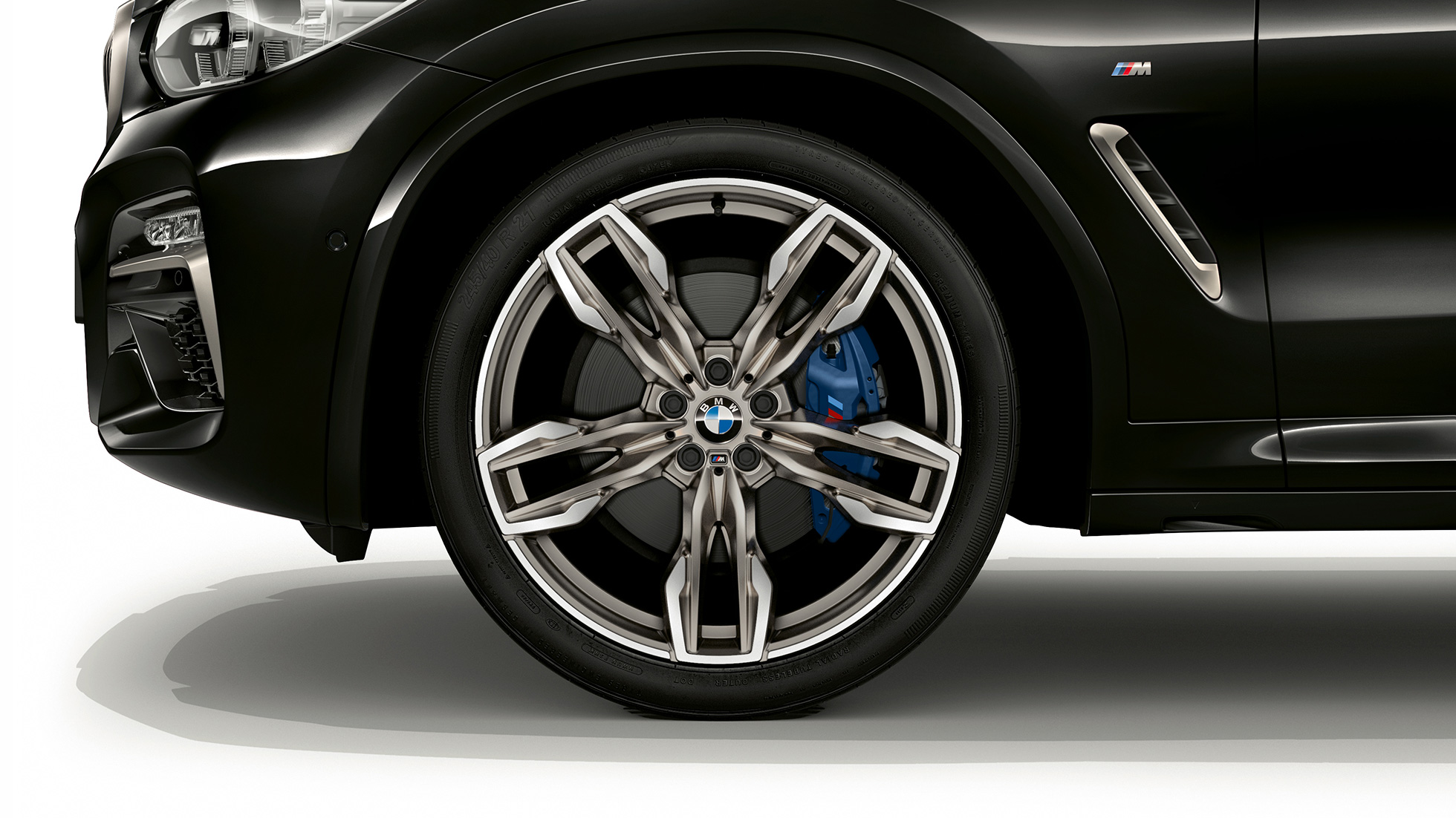 BMW X4 M40i a BMW X4 M40d, 21palcová M kola z lehké slitiny. BMW X4 M40i a BMW X4 M40d v černé metalické barvě Black Sapphire, exteriér, boční pohled s 21palcovými koly z lehké slitiny v designu double-spoke.