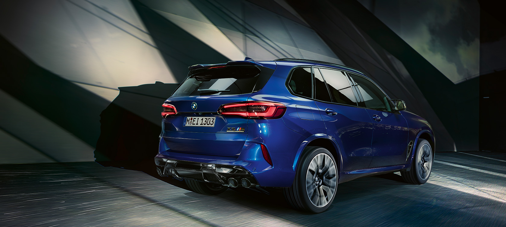 Tříčtvrteční pohled zezadu na BMW X5 M Competition Tříčtvrteční pohled zezadu na BMW X5 M Competition F95 2020 v modré barvě Marina Bay Blue