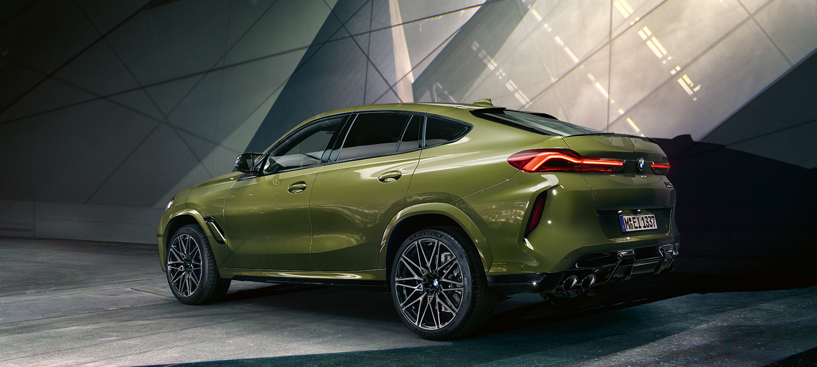 Tříčtvrteční pohled zezadu na BMW X6 M Competition Tříčtvrteční pohled zezadu na BMW X6 M Competition F96 2020 ve speciální barvě BMW Individual Urban Green