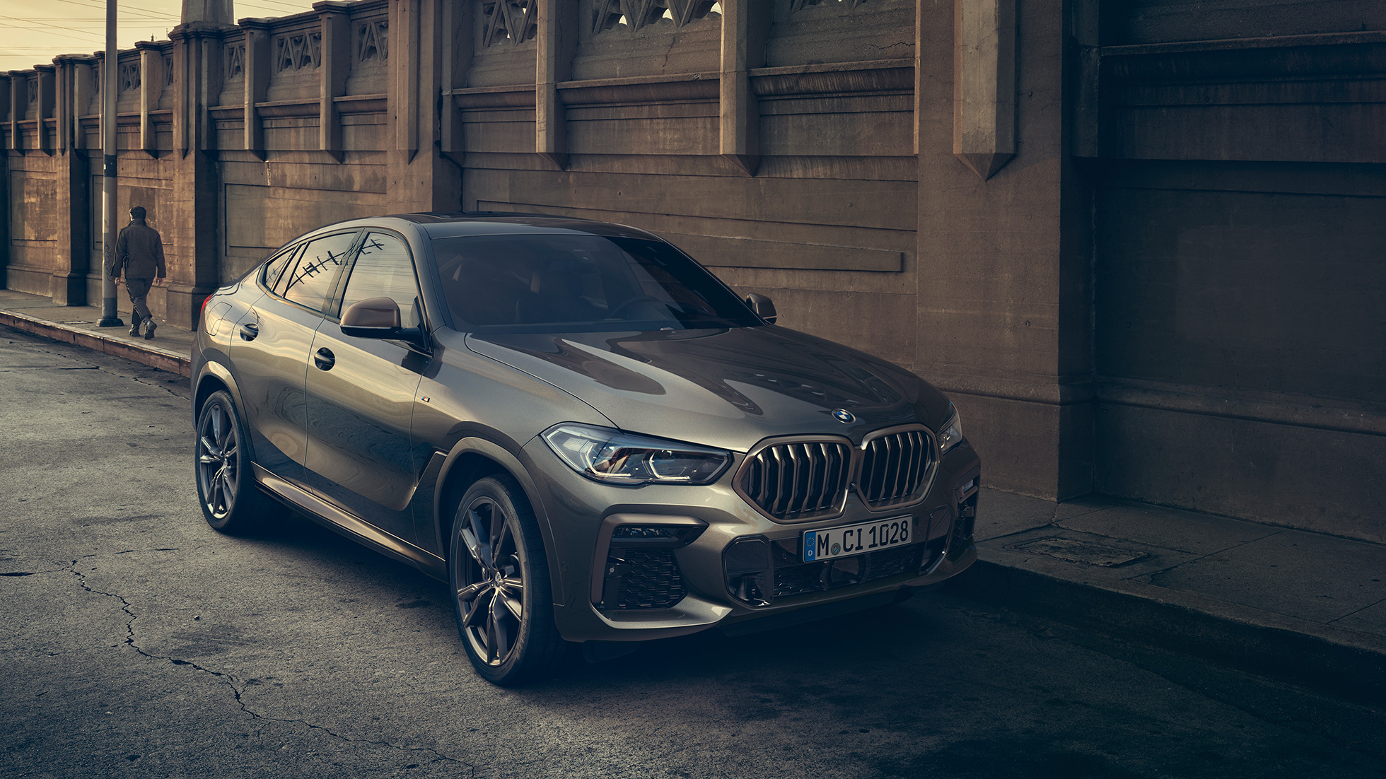 BMW X6 M50i se zážehovým 8válcem M TwinPower Turbo Tříčtvrteční pohled z boku na BMW X6 M50i G06 se zážehovým 8válcem M TwinPower Turbo s metalickým lakem Manhattan