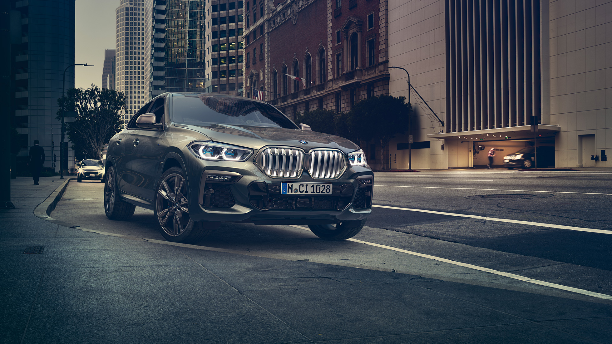 BMW X6 M50i stojící Přední tříčtvrteční pohled na BMW X6 M50i před městským prostředím.