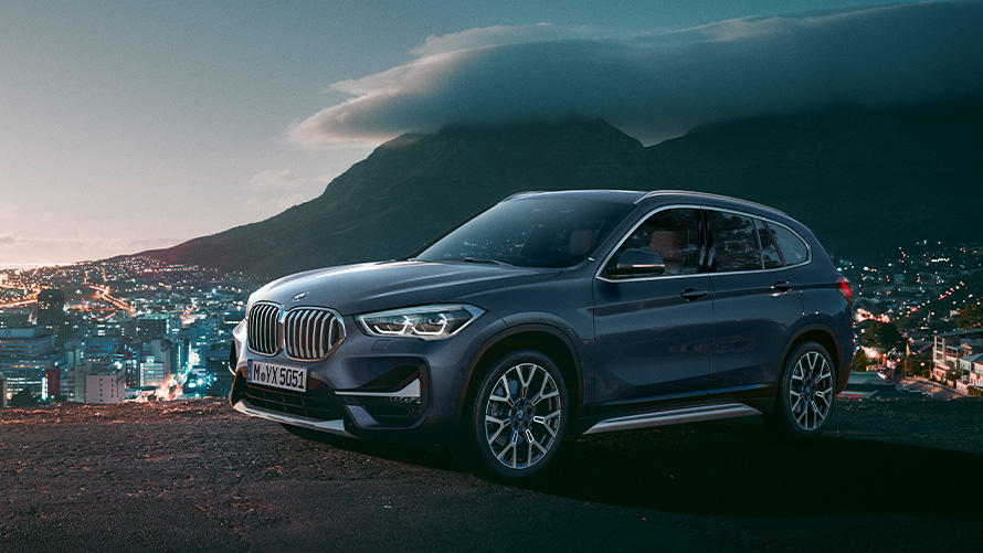 BMW X1 F48 druhá generace, statický tříčtvrteční pohled z boku před městem BMW řady X BMW X1 F48 druhá generace, statický tříčtvrteční pohled z boku před městem