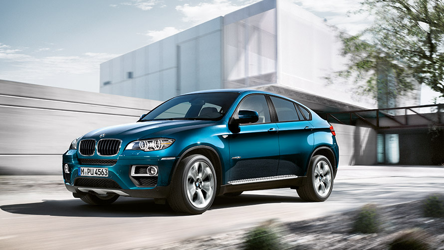 BMW X6 E71 první generace, tříčtvrteční statický záběr z boku před budovou BMW řady X BMW X6 E71 první generace, tříčtvrteční statický záběr z boku před budovou