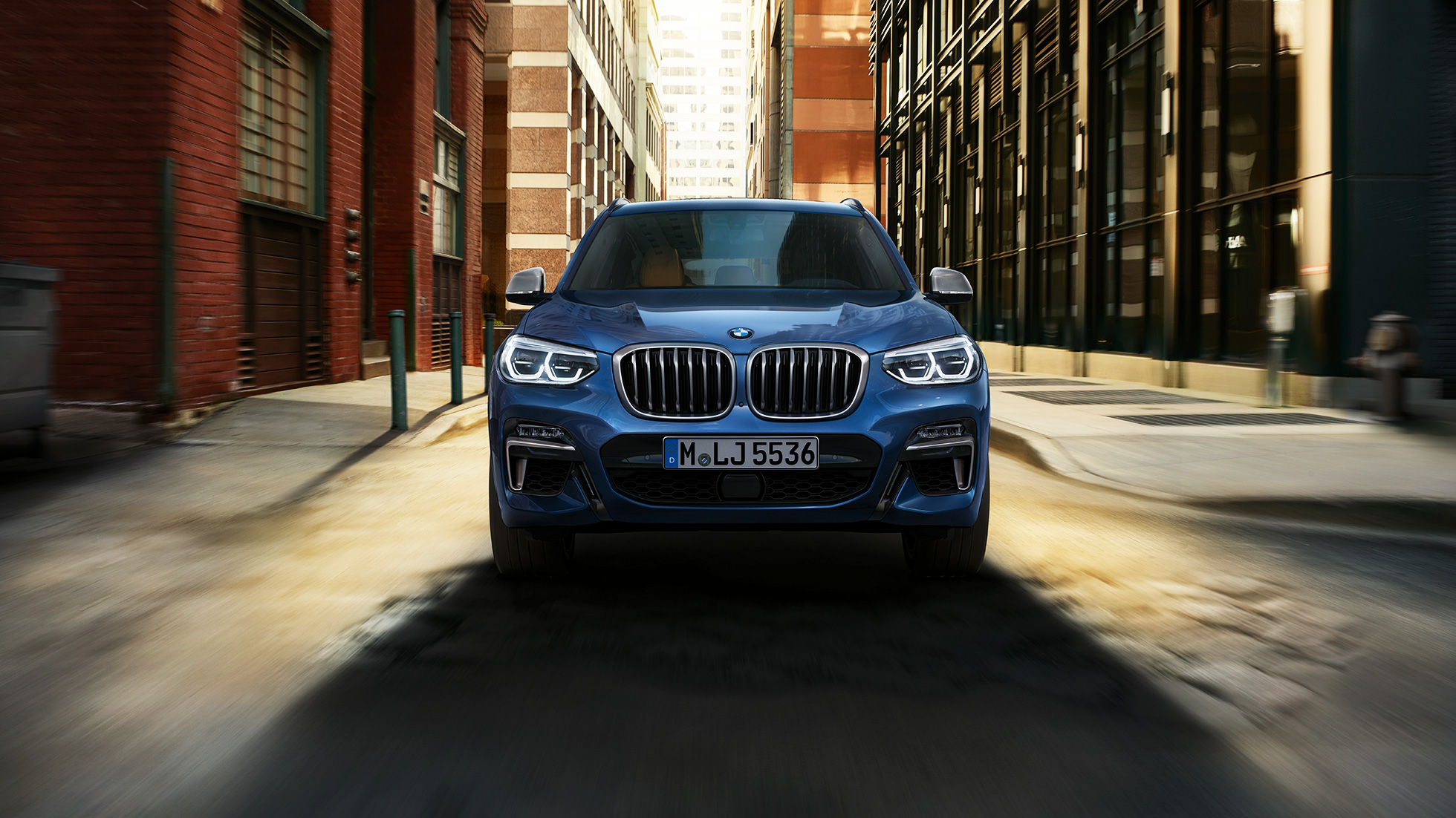 BMW X3 M40i, záběr zpředu před městskou zástavbou BMW X3 M40i, záběr zpředu před městskou zástavbou