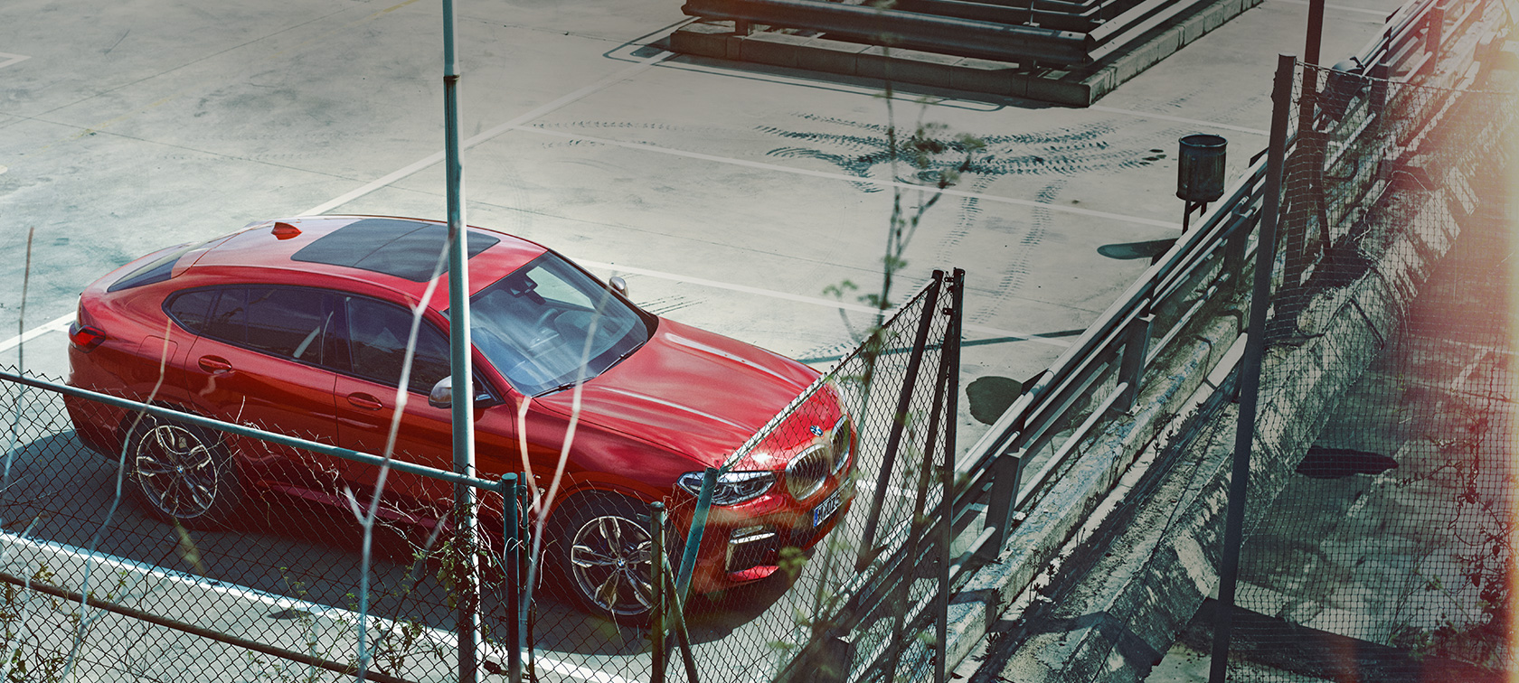 BMW X4 parkování BMW X4 G02 2018 v metalické barvě Flamenco Red (červená) se zářivým efektem v parkovacím místě z ptačí perspektivy