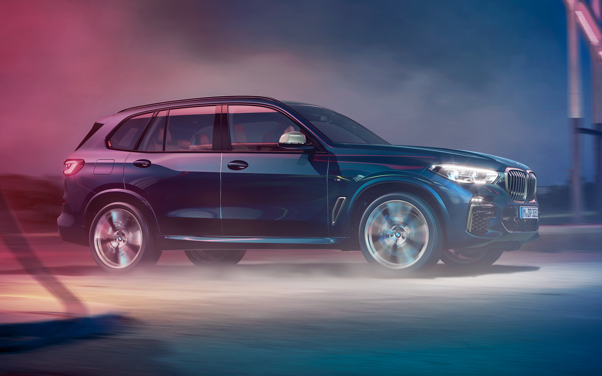 BMW X5 M50d v pohybu Noční jízdní záběr BMW X5 M50d v městském prostředí