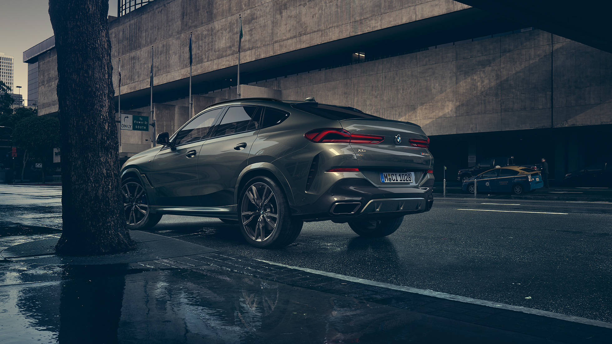 Exteriér BMW X6. Tříčtvrteční pohled zezadu na BMW X6 stojící před městskou zástavbou.