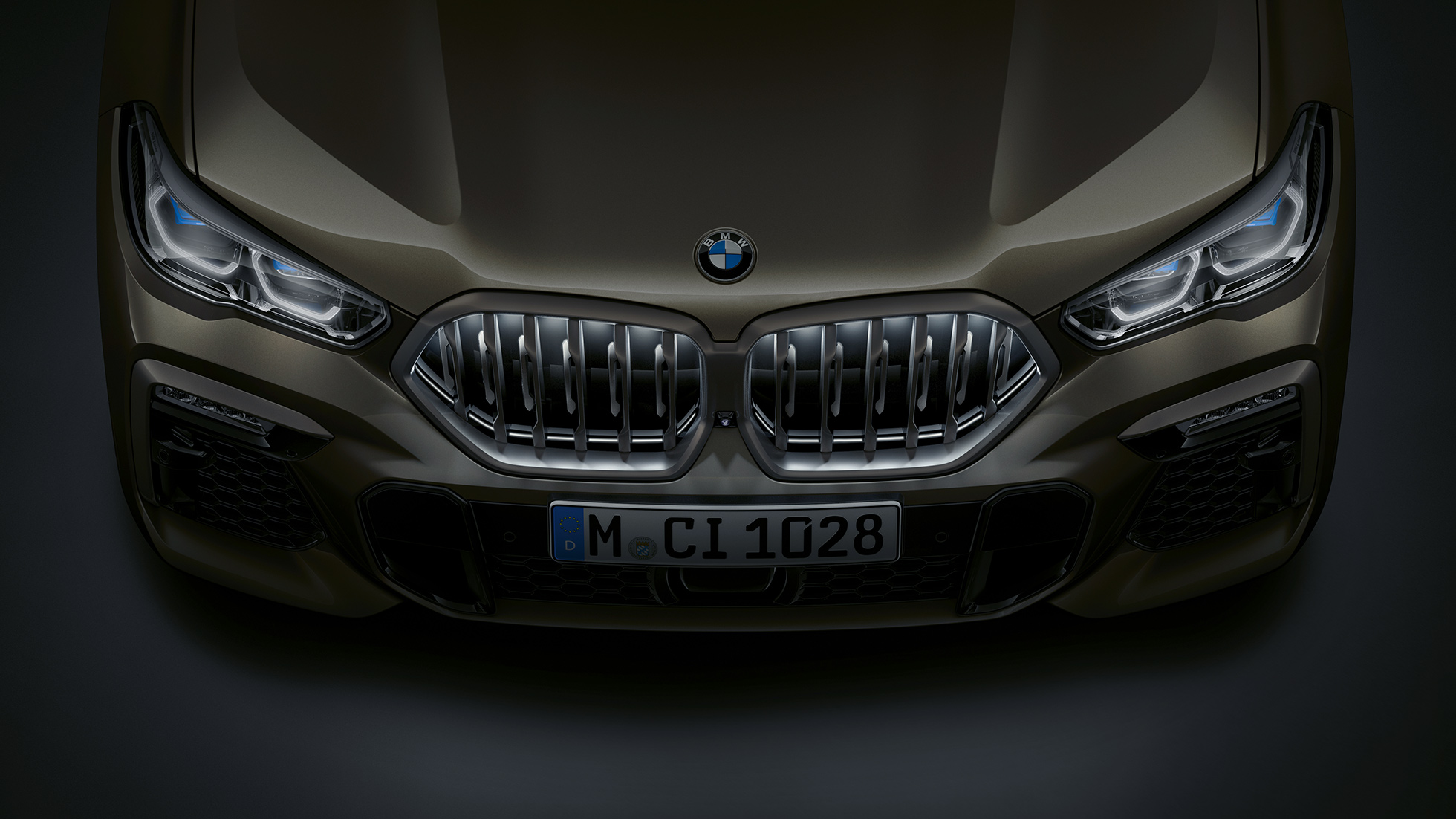 Příď BMW X6. Detailní pohled z ptačí perspektivy na přední část BMW X6 s BMW maskou chladiče Iconic Glow.