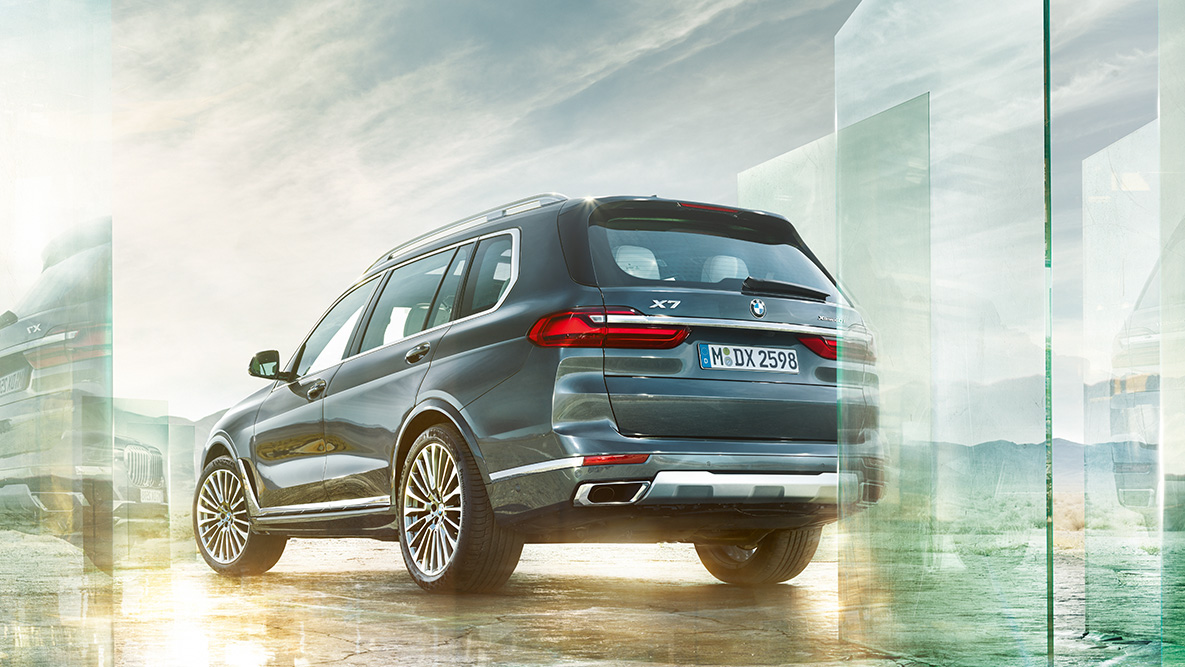 BMW X7 Komfort a Jízdní dynamika BMW X7 v šikmém zadním pohledu s abstraktním pozadím