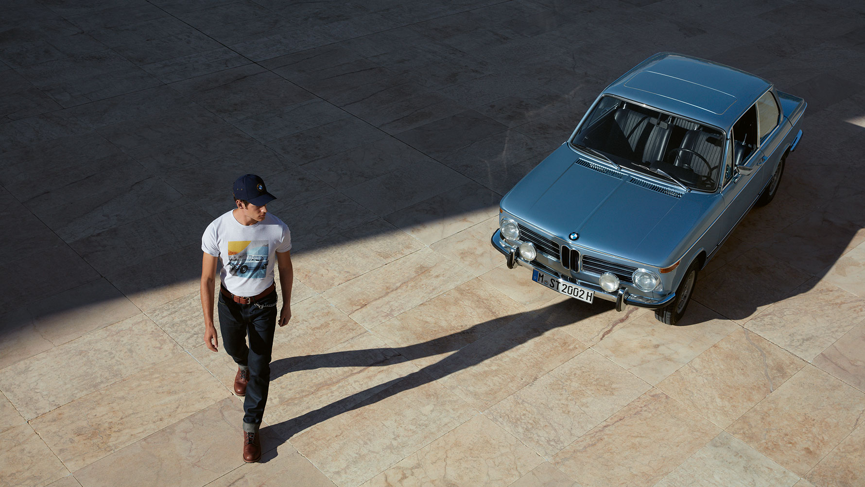 Muž obdivující klasický automobil BMW má na sobě triko z kolekce BMW Classic. Muž obdivující klasický automobil BMW má na sobě triko z kolekce BMW Classic.