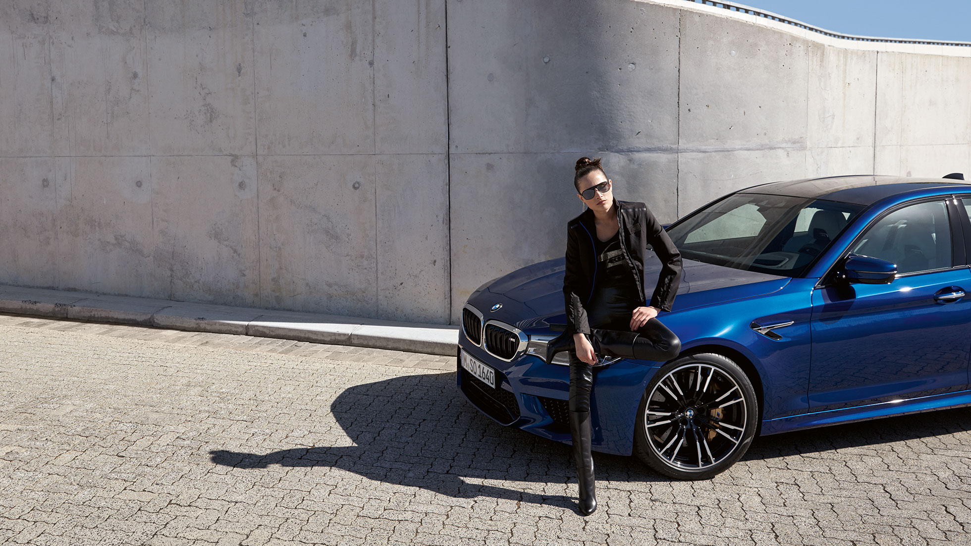 Kolekce BMW M. Žena na obrázku je oblečená do dámské bundy BMW M.