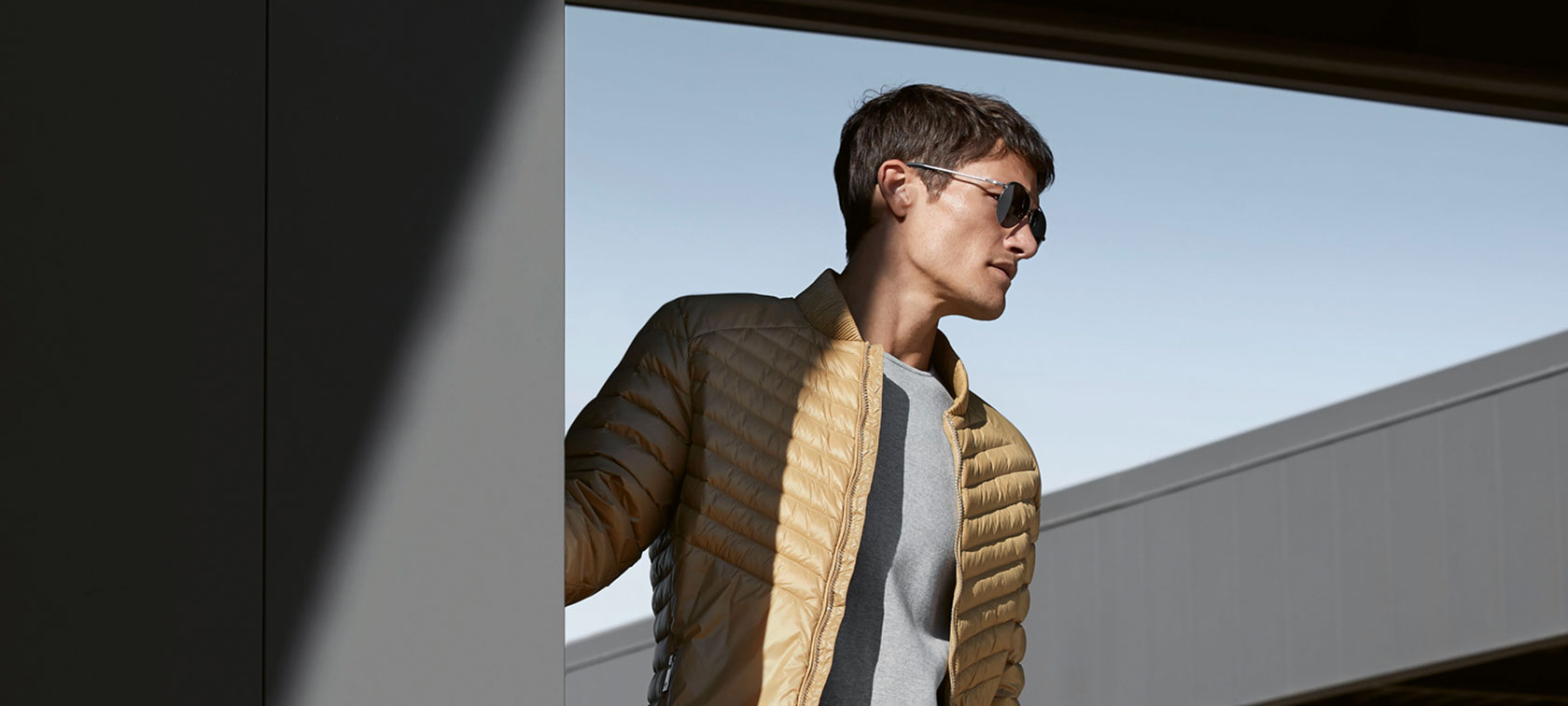 Fotografie zobrazuje mladého muže v pánské bundě BMW Soft Down Jacket. Fotografie zobrazuje mladého muže v pánské bundě BMW Soft Down Jacket.