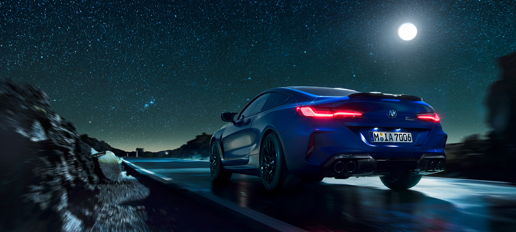 BMW M8 Competition Coupé, pohled zezadu. BMW M8 Competition Coupé, pohled zezadu, jízdní záběr v noci za úplňku.