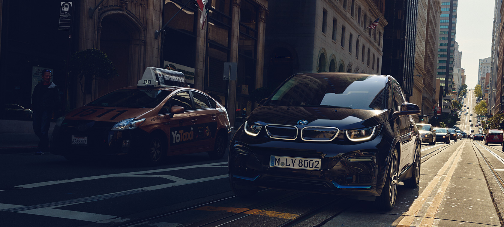 BMW i3 na silnici Elektrické vozy BMW i3 na silnici ze tříčtvrtečního pohledu zepředu