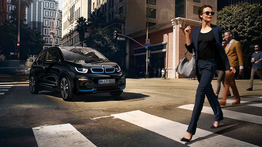 BMW i3s proti městskému pozadí Nabíjení BMW při každodenním používání BMW i3s proti městskému pozadí