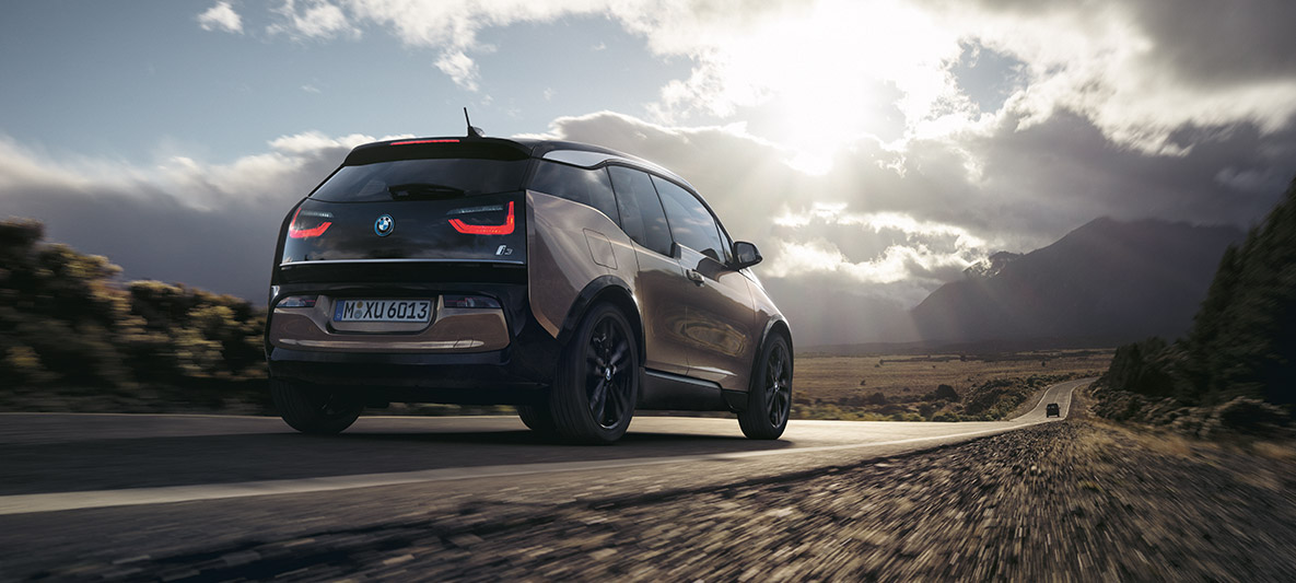 BMW i3s proti horské scenérii Příklad dojezdu BMW, BMW i3s proti horské scenérii ze tříčtvrtečního pohledu zezadu
