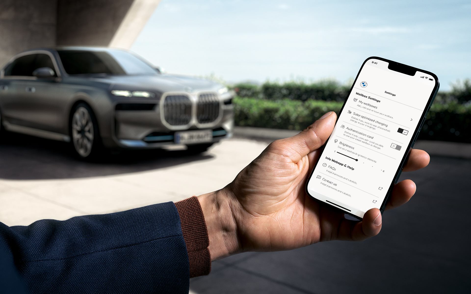 BMW i7 G70 Telefon v popředí ukazující aplikaci My BMW